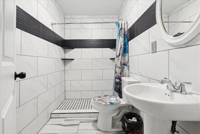 bathroom with a shower with shower curtain, sink, toilet, and tile walls