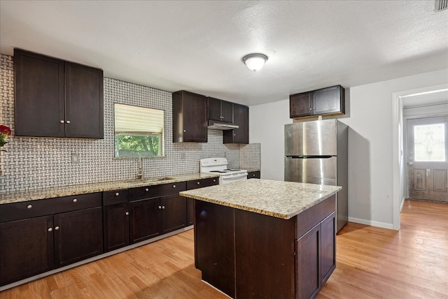 kitchen with stainless steel fridge, white range, dark brown cabinetry, and sink