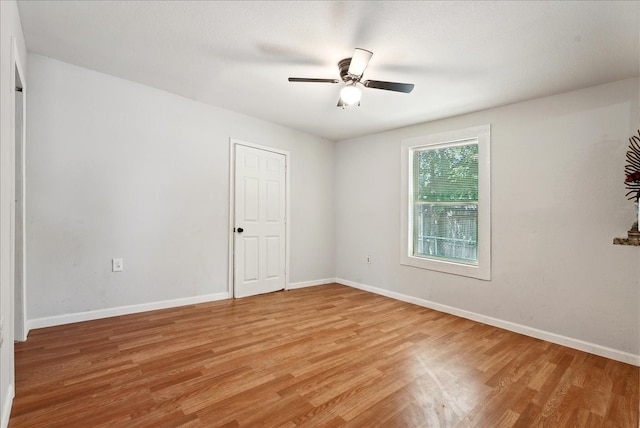 empty room with ceiling fan and hardwood / wood-style flooring