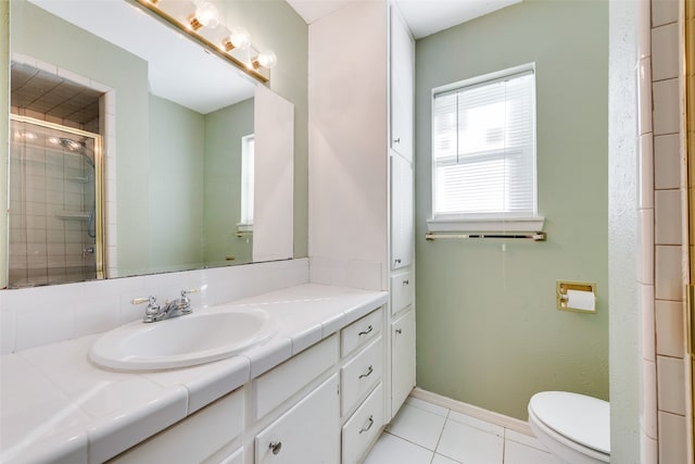 bathroom with tile patterned floors, vanity, an enclosed shower, and toilet