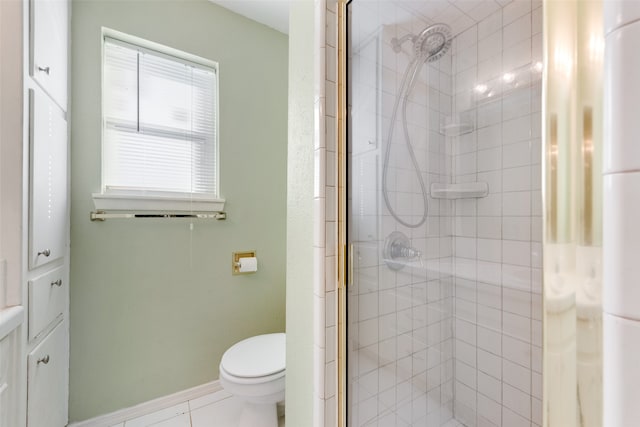 bathroom featuring tile patterned floors, toilet, and tiled shower