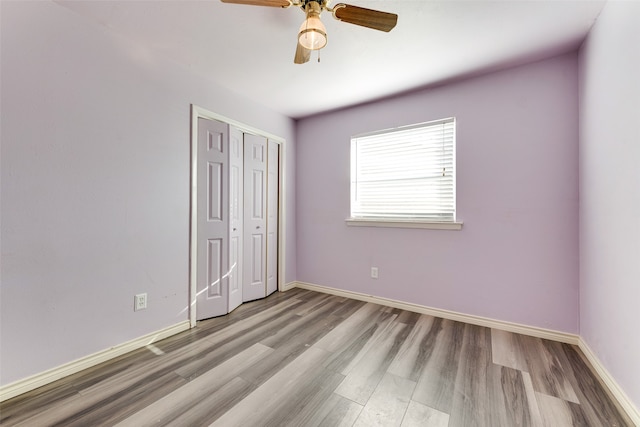 unfurnished bedroom featuring ceiling fan, light wood-type flooring, and a closet