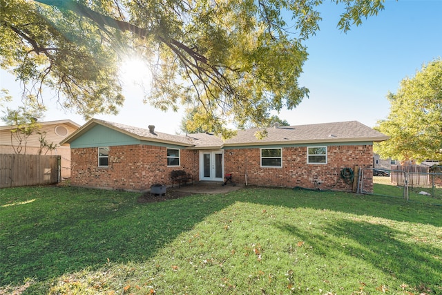 rear view of property with a lawn and french doors