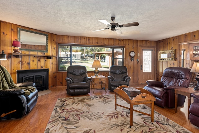 living room featuring plenty of natural light, ceiling fan, a textured ceiling, and light hardwood / wood-style flooring