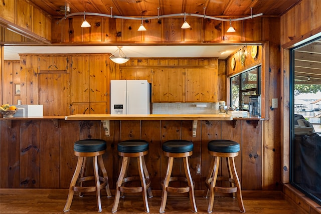 kitchen with white fridge with ice dispenser, wooden walls, and wooden ceiling