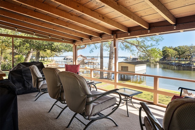 sunroom with vaulted ceiling with beams, a water view, and wood ceiling