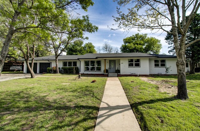 ranch-style home with a front lawn and a garage