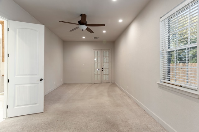 carpeted spare room featuring french doors, plenty of natural light, and ceiling fan