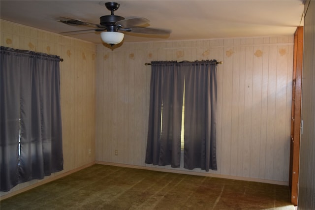 empty room with dark colored carpet and ceiling fan