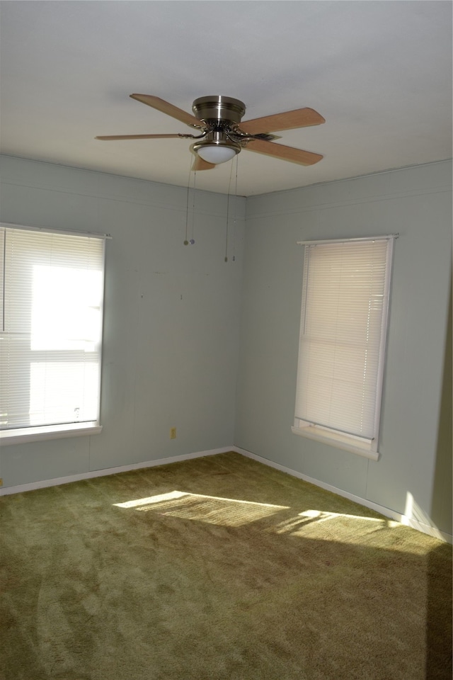 carpeted spare room featuring ceiling fan