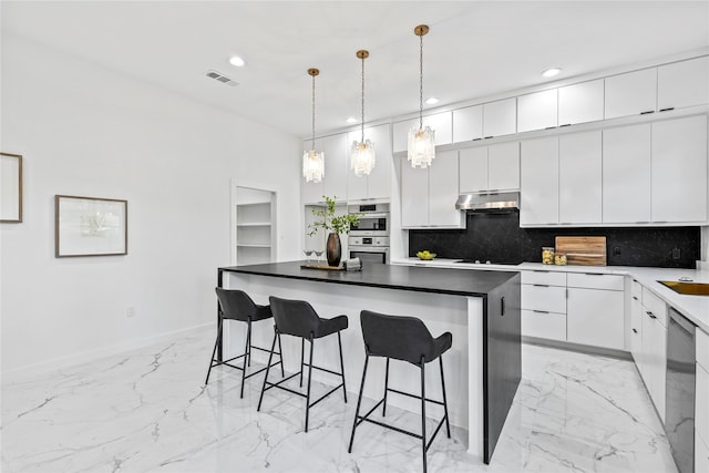 kitchen featuring white cabinetry, tasteful backsplash, a center island, and dishwasher