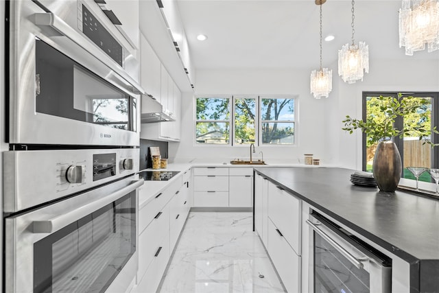 kitchen with white cabinetry, sink, wine cooler, hanging light fixtures, and black electric stovetop