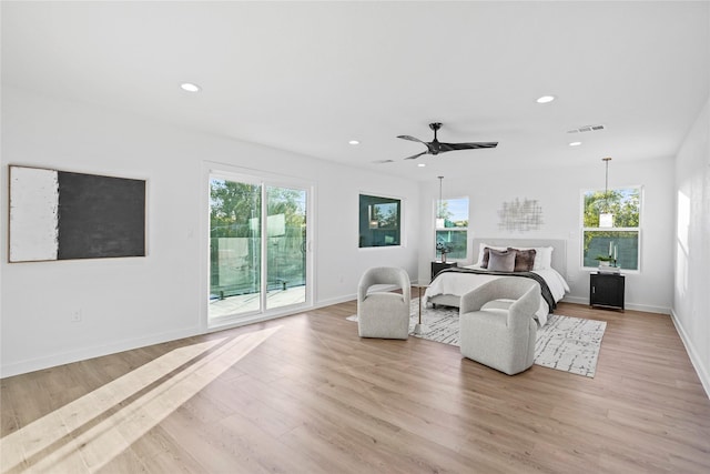 bedroom with multiple windows, access to exterior, ceiling fan, and light hardwood / wood-style flooring