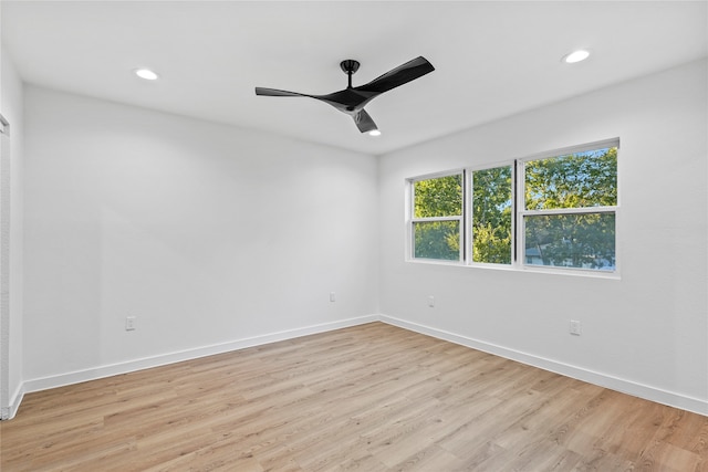 empty room with ceiling fan and light hardwood / wood-style flooring