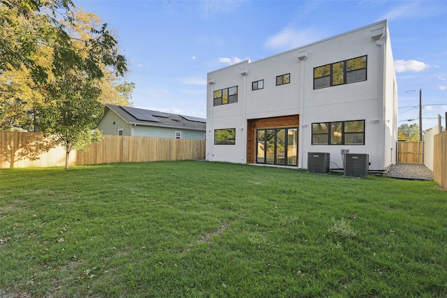 back of property with cooling unit and a lawn