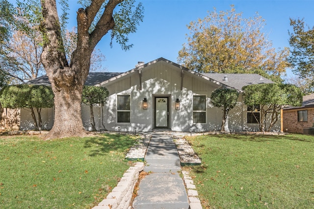 view of front of home featuring cooling unit and a front lawn