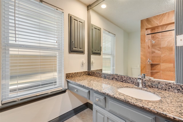 bathroom featuring tile patterned floors, vanity, a wealth of natural light, and a shower