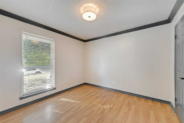 empty room featuring light wood-type flooring, a textured ceiling, and ornamental molding