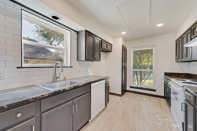 kitchen featuring backsplash, a healthy amount of sunlight, white appliances, and sink