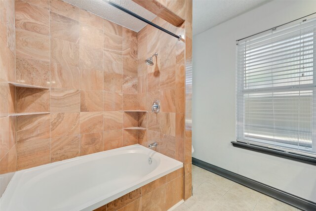 bathroom featuring tile patterned flooring, a textured ceiling, and tiled shower / bath combo