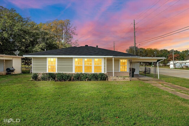 single story home with a carport and a lawn