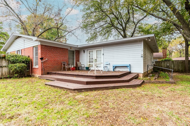 rear view of property with a lawn and a deck