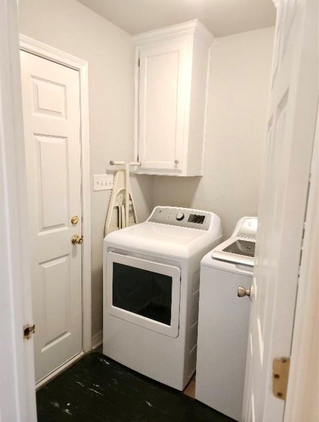 washroom featuring washing machine and dryer and cabinets