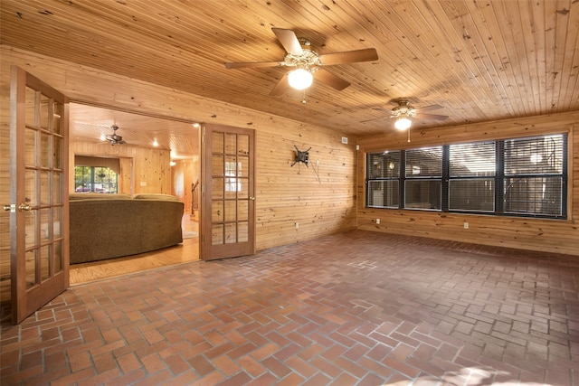 empty room with wood ceiling, wooden walls, and french doors