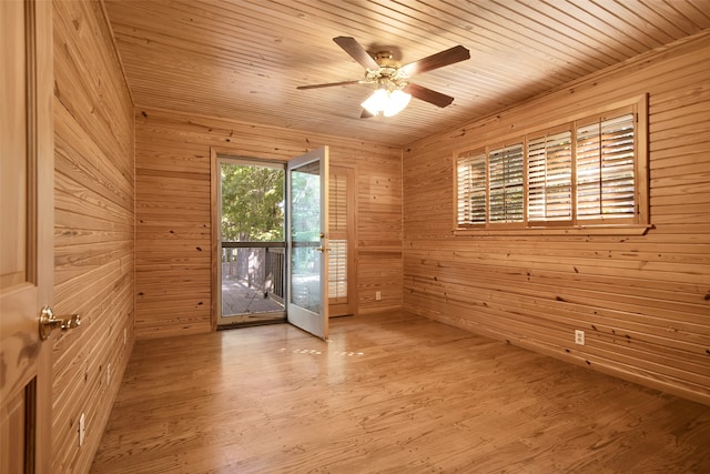 empty room featuring light hardwood / wood-style flooring, ceiling fan, wooden ceiling, and wood walls