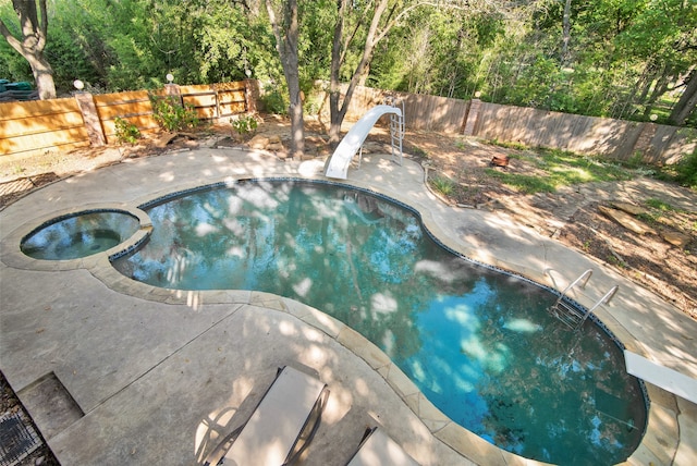 view of pool featuring a patio area, an in ground hot tub, and a water slide