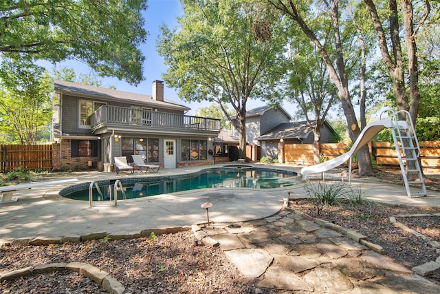 view of pool featuring a diving board, a patio area, and a water slide