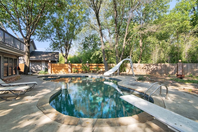 view of swimming pool featuring a jacuzzi, a diving board, a patio area, and a water slide