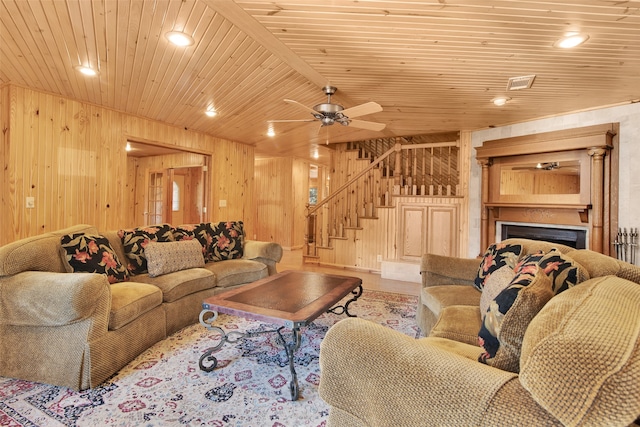 living room featuring wood walls, ceiling fan, and wooden ceiling