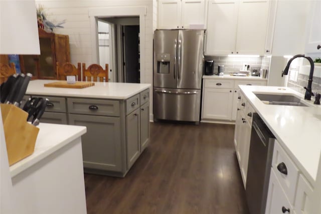 kitchen with sink, gray cabinets, appliances with stainless steel finishes, white cabinetry, and dark hardwood / wood-style floors