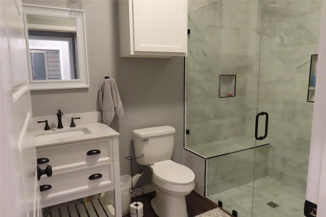 bathroom featuring walk in shower, vanity, and toilet