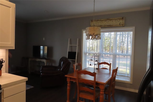 dining space featuring dark wood-type flooring, crown molding, and an inviting chandelier