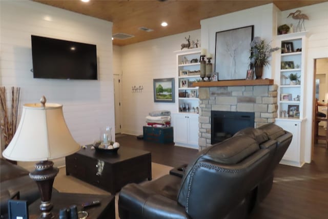 living room featuring a stone fireplace, dark hardwood / wood-style floors, and wooden ceiling