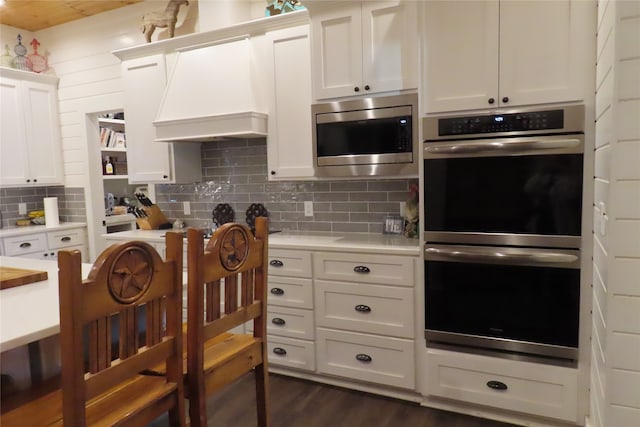 kitchen with decorative backsplash, dark hardwood / wood-style floors, white cabinetry, and appliances with stainless steel finishes