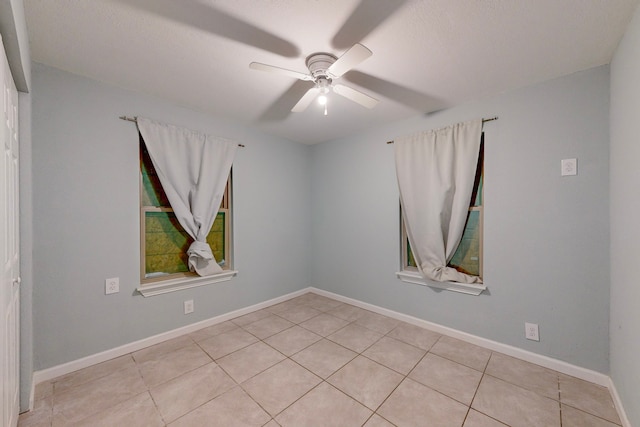 tiled spare room featuring ceiling fan