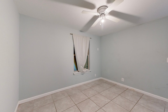 tiled spare room featuring ceiling fan