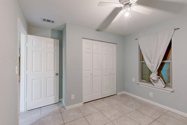 unfurnished bedroom featuring ceiling fan, light tile patterned floors, and a closet