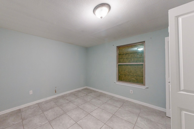 unfurnished room featuring light tile patterned floors and a textured ceiling