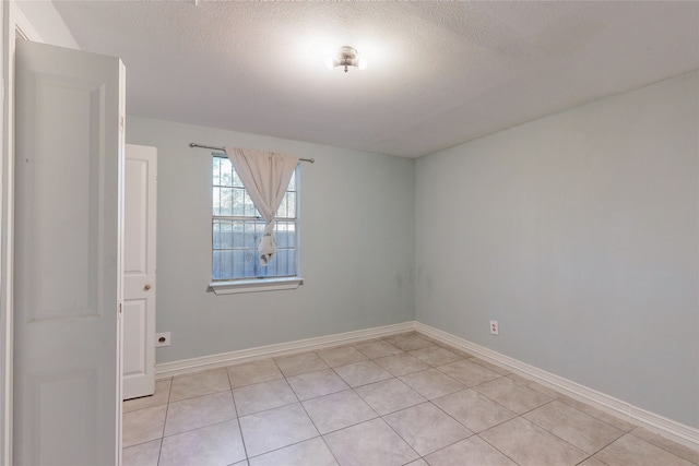 tiled spare room featuring a textured ceiling