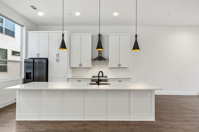 kitchen with a center island with sink, sink, decorative light fixtures, white cabinetry, and stainless steel appliances