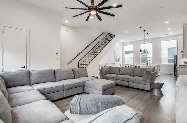 living room with hardwood / wood-style flooring, ceiling fan, and sink