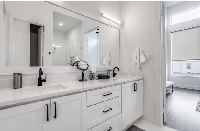 bathroom featuring hardwood / wood-style floors, vanity, and walk in shower