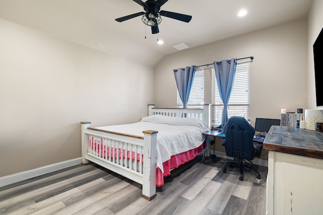 bedroom with ceiling fan, lofted ceiling, and wood-type flooring