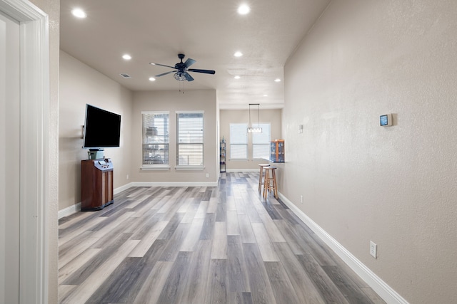 unfurnished living room featuring ceiling fan and light wood-type flooring