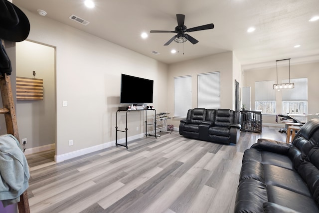 living room featuring light hardwood / wood-style flooring and ceiling fan