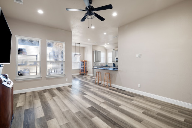 unfurnished living room featuring ceiling fan and light hardwood / wood-style flooring